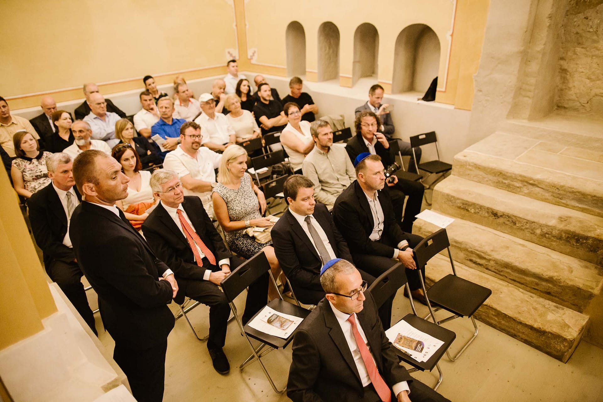 The crowd seated inside the Old Synagogue